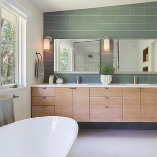 Esempio di una stanza da bagno padronale minimalista di medie dimensioni con lavabo integrato, ante lisce, ante in legno chiaro, vasca freestanding, piastrelle grigie e pareti bianche