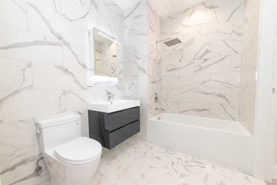 Bathroom - mid-sized modern 3/4 marble tile marble floor and gray floor bathroom idea in New York with flat-panel cabinets, gray cabinets, a one-piece toilet, an integrated sink, solid surface countertops and white countertops