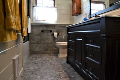 Example of a mid-sized master gray tile and ceramic tile mosaic tile floor and gray floor bathroom design in New York with recessed-panel cabinets, black cabinets, a two-piece toilet, white walls, an undermount sink and granite countertops
