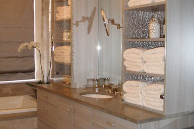 ワシントンD.C.にある中くらいなコンテンポラリースタイルのおしゃれな浴室 (フラットパネル扉のキャビネット、グレーのキャビネット、ドロップイン型浴槽、グレーのタイル、石タイル、白い壁、ライムストーンの床、アンダーカウンター洗面器、ライムストーンの洗面台) の写真