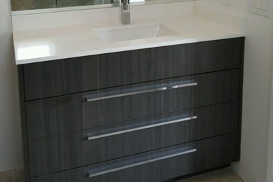 Modelo de cuarto de baño contemporáneo con armarios con paneles lisos, puertas de armario negras, lavabo integrado, encimera de acrílico, suelo gris y encimeras blancas
