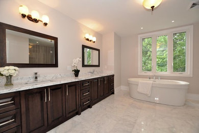 Diseño de cuarto de baño principal moderno grande con puertas de armario de madera en tonos medios, jacuzzi, sanitario de dos piezas, baldosas y/o azulejos blancos, suelo de mármol y paredes beige