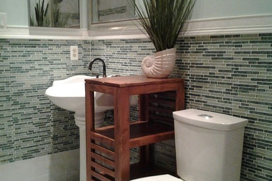 Mid-sized master blue tile and glass sheet doorless shower photo in Tampa with a pedestal sink, furniture-like cabinets, medium tone wood cabinets, a two-piece toilet and blue walls