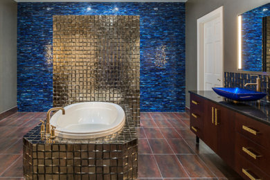 Example of a mid-sized eclectic master beige tile and metal tile porcelain tile and brown floor drop-in bathtub design in St Louis with flat-panel cabinets, dark wood cabinets, beige walls, a vessel sink, quartz countertops and black countertops
