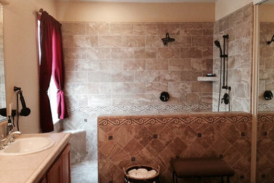 サクラメントにある広いおしゃれな浴室 (オーバーカウンターシンク、中間色木目調キャビネット、オープン型シャワー、ベージュのタイル) の写真