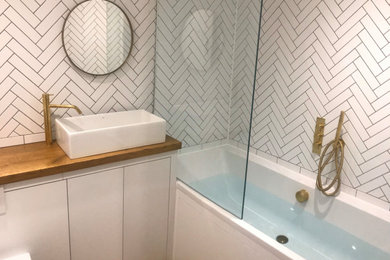バッキンガムシャーにある小さなトラディショナルスタイルのおしゃれな浴室 (白いキャビネット、白いタイル、白い壁、無垢フローリング、木製洗面台、洗面台1つ、造り付け洗面台) の写真