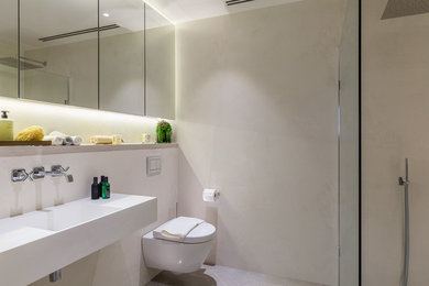 Imagen de cuarto de baño principal contemporáneo pequeño con sanitario de pared, baldosas y/o azulejos grises, paredes grises, lavabo suspendido, suelo gris y ducha abierta