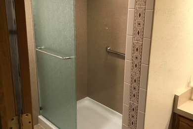 他の地域にある低価格の中くらいなトラディショナルスタイルのおしゃれなバスルーム (浴槽なし) (アルコーブ型シャワー、ベージュのタイル、ベージュの壁、ラミネートカウンター、引戸のシャワー) の写真