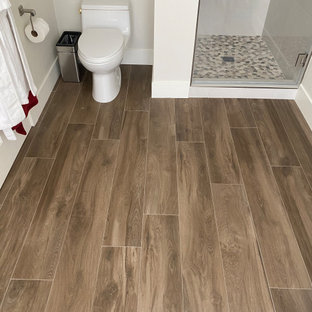 Modern inredning av ett mellanstort flerfärgad flerfärgat en-suite badrum, med skåp i shakerstil, skåp i mörkt trä, ett fristående badkar, en dusch i en alkov, en toalettstol med hel cisternkåpa, beige kakel, porslinskakel, beige väggar, ett undermonterad handfat, bänkskiva i kvarts, brunt golv och dusch med gångjärnsdörr