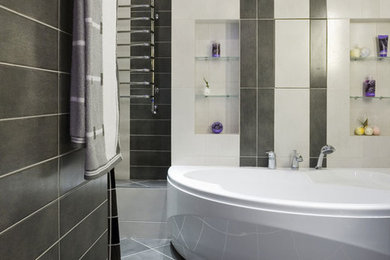 ミルウォーキーにある高級な広いコンテンポラリースタイルのおしゃれなマスターバスルーム (置き型浴槽、シャワー付き浴槽	、一体型トイレ	、グレーのタイル、石タイル) の写真