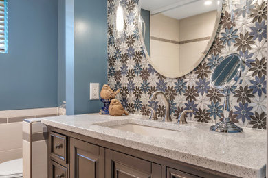 На фото: маленькая детская ванная комната в современном стиле с плоскими фасадами, коричневыми фасадами, ванной в нише, душем над ванной, унитазом-моноблоком, разноцветной плиткой, плиткой мозаикой, синими стенами, полом из керамической плитки, врезной раковиной, столешницей из кварцита, серым полом, шторкой для ванной и белой столешницей для на участке и в саду с
