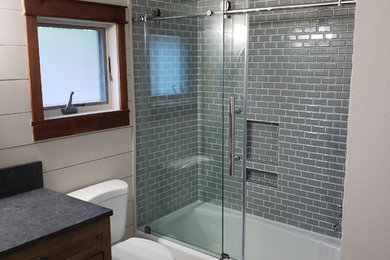 Example of a gray tile and porcelain tile ceramic tile and white floor bathroom design in Other with a two-piece toilet, gray walls, an undermount sink and granite countertops