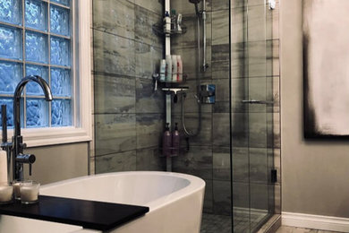 Medium sized contemporary ensuite bathroom in Calgary with flat-panel cabinets, white cabinets, a one-piece toilet, grey tiles, porcelain tiles, grey walls, a submerged sink, a hinged door, white worktops, a freestanding bath, a corner shower, quartz worktops and grey floors.