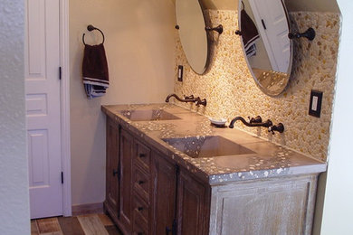 Bathroom remodel featuring concrete vanity with integrated sinks and rock inlays