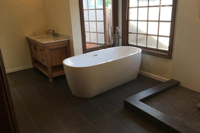 Bathroom - large contemporary master porcelain tile and black floor bathroom idea in Orange County with furniture-like cabinets, medium tone wood cabinets, beige walls and an undermount sink