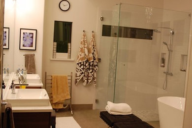 Diseño de cuarto de baño principal actual de tamaño medio con bañera exenta, ducha a ras de suelo, baldosas y/o azulejos blancos, paredes blancas, suelo gris y ducha con puerta con bisagras