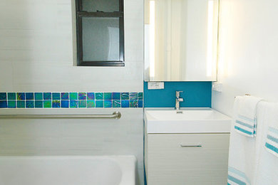 Photo of a medium sized modern bathroom in New York with a corner bath, a shower/bath combination, a one-piece toilet, white tiles, ceramic tiles, white walls, ceramic flooring, a wall-mounted sink, grey floors and an open shower.