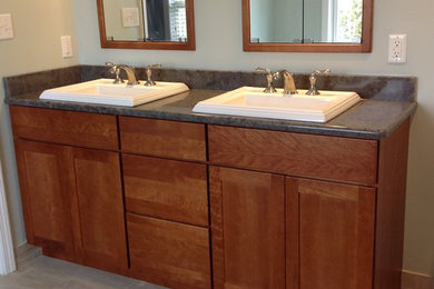 Diseño de cuarto de baño clásico con armarios estilo shaker, puertas de armario de madera oscura y encimera de cuarzo compacto