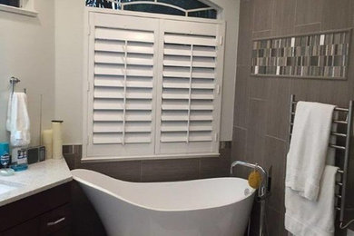Mid-sized transitional master gray tile and porcelain tile porcelain tile bathroom photo in Miami with flat-panel cabinets, dark wood cabinets, white walls, an undermount sink and quartz countertops