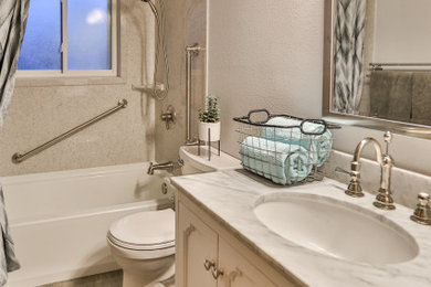 Example of a southwest 3/4 medium tone wood floor, brown floor and single-sink bathroom design in Denver with furniture-like cabinets, white cabinets, a two-piece toilet, white walls, a drop-in sink, solid surface countertops and gray countertops