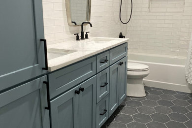 Example of a mid-sized transitional 3/4 white tile and subway tile porcelain tile and black floor bathroom design in New York with shaker cabinets, blue cabinets, a two-piece toilet, white walls, an undermount sink, marble countertops and white countertops