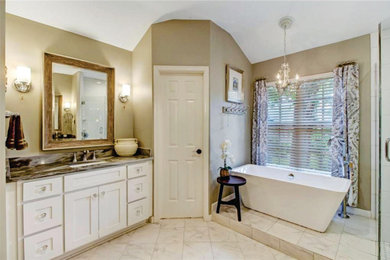 Example of a mid-sized french country master porcelain tile and white floor freestanding bathtub design in Jacksonville with white cabinets, beige walls, an undermount sink, granite countertops, gray countertops and shaker cabinets