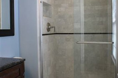 ニューヨークにある小さなおしゃれなバスルーム (浴槽なし) (濃色木目調キャビネット、御影石の洗面台、コーナー設置型シャワー、一体型トイレ	、ベージュのタイル、青い壁、セラミックタイルの床) の写真