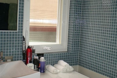 Foto de cuarto de baño moderno con armarios con paneles lisos, puertas de armario negras, encimera de acrílico, baldosas y/o azulejos blancos, baldosas y/o azulejos de porcelana y suelo de baldosas de porcelana