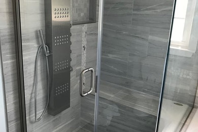 ボルチモアにある低価格のトラディショナルスタイルのおしゃれな浴室 (コーナー設置型シャワー、グレーのタイル、磁器タイル、磁器タイルの床、グレーの床、開き戸のシャワー) の写真
