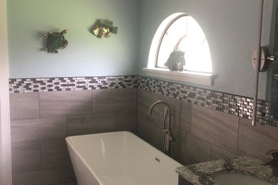Example of a mid-sized trendy master bathroom design in Orlando with shaker cabinets, gray cabinets, quartzite countertops and a hinged shower door
