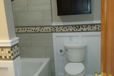 Bathroom - mid-sized contemporary 3/4 gray tile and ceramic tile ceramic tile bathroom idea in New York with an undermount sink, shaker cabinets, black cabinets, quartz countertops, a two-piece toilet and beige walls