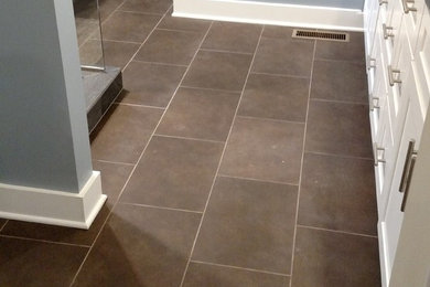 Example of a minimalist ceramic tile and brown floor bathroom design in Indianapolis with gray walls