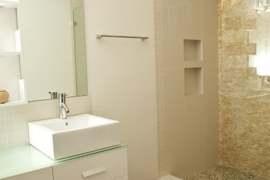 This is an example of a medium sized classic ensuite bathroom in Los Angeles with flat-panel cabinets, white cabinets, an alcove shower, beige tiles, stone tiles, white walls, porcelain flooring, a vessel sink, glass worktops, brown floors and an open shower.
