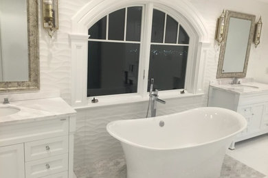 Идея дизайна: большая главная ванная комната в стиле кантри с белыми фасадами, отдельно стоящей ванной, угловым душем, биде, белой плиткой, керамогранитной плиткой, белыми стенами, полом из керамогранита, накладной раковиной, столешницей из кварцита, белым полом и душем с раздвижными дверями