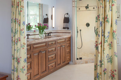Bathroom - mid-sized contemporary master beige tile and porcelain tile porcelain tile and beige floor bathroom idea in San Diego with raised-panel cabinets, medium tone wood cabinets, a one-piece toilet, blue walls, an undermount sink, granite countertops and a hinged shower door