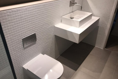 Foto de cuarto de baño infantil minimalista de tamaño medio con bañera encastrada, combinación de ducha y bañera, baldosas y/o azulejos blancos, baldosas y/o azulejos en mosaico y lavabo suspendido