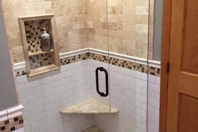 Mid-sized elegant master white tile and subway tile travertine floor and beige floor bathroom photo in Minneapolis with shaker cabinets, dark wood cabinets, a one-piece toilet, green walls, an integrated sink, solid surface countertops and a hinged shower door