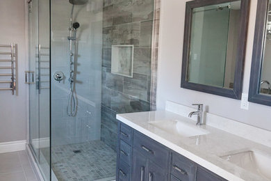 Bathroom - large transitional master gray tile and porcelain tile porcelain tile bathroom idea in Toronto with raised-panel cabinets, gray cabinets, gray walls, an undermount sink and limestone countertops