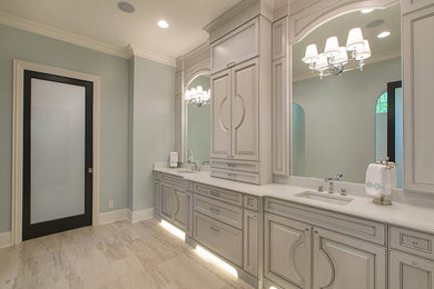 Example of a mid-sized trendy master travertine floor and beige floor bathroom design in Charlotte with shaker cabinets, gray cabinets, blue walls, an undermount sink and quartz countertops