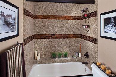 На фото: ванная комната среднего размера с душем над ванной, коричневой плиткой и стеклянной плиткой