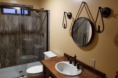Inspiration for a mid-sized rustic 3/4 single-sink bathroom remodel in Other with medium tone wood cabinets, a two-piece toilet, beige walls, a drop-in sink, wood countertops, brown countertops and a freestanding vanity
