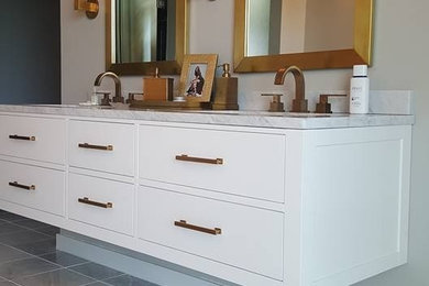 Ejemplo de cuarto de baño contemporáneo con armarios con paneles lisos, puertas de armario blancas, paredes blancas, suelo de mármol, lavabo bajoencimera, suelo blanco y encimeras blancas