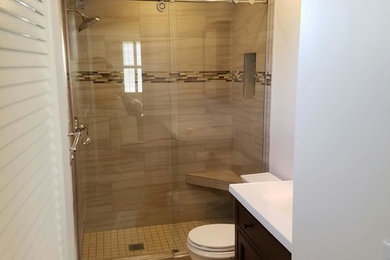 サンフランシスコにあるトランジショナルスタイルのおしゃれな浴室 (濃色木目調キャビネット、アルコーブ型シャワー、磁器タイルの床、珪岩の洗面台、茶色い床、開き戸のシャワー) の写真