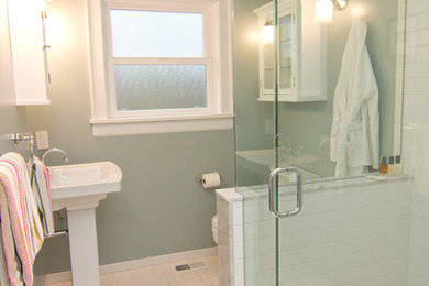 Example of a mid-sized trendy 3/4 white tile and ceramic tile ceramic tile and white floor corner shower design in Seattle with glass-front cabinets, white cabinets, a two-piece toilet, blue walls, a pedestal sink and a hinged shower door