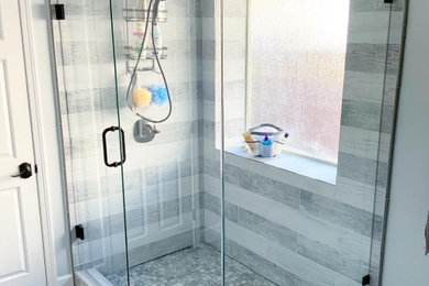 Example of a pebble tile floor and gray floor tub/shower combo design in Dallas