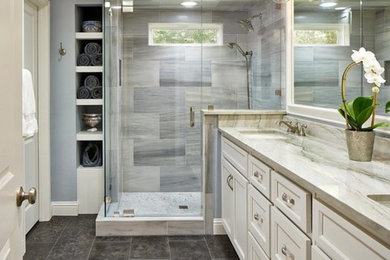 Inspiration for a mid-sized transitional 3/4 gray tile and porcelain tile porcelain tile and black floor corner shower remodel in Los Angeles with recessed-panel cabinets, white cabinets, gray walls, an undermount sink, marble countertops, a hinged shower door and gray countertops
