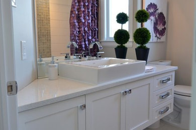 Mid-sized transitional master bathroom photo in Ottawa with recessed-panel cabinets, white cabinets, a two-piece toilet, beige walls, a vessel sink and solid surface countertops