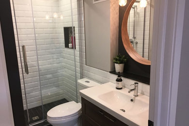 Bathroom - mid-sized contemporary white tile and subway tile bathroom idea in Other with white cabinets, a two-piece toilet, black walls, a pedestal sink, solid surface countertops and black countertops