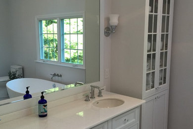 Ejemplo de cuarto de baño principal clásico renovado con lavabo bajoencimera, armarios con paneles empotrados, puertas de armario blancas y encimera de acrílico