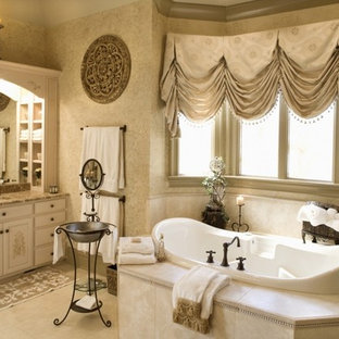 Ispirazione per un'ampia stanza da bagno padronale vittoriana con ante lisce, ante beige, vasca da incasso, piastrelle beige, pareti beige, lavabo sottopiano, top in granito e pavimento beige